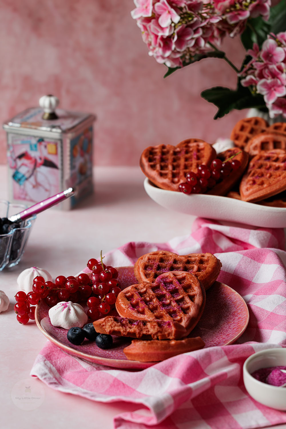Kleine Herzwaffeln liegen auf einem pinken Teller