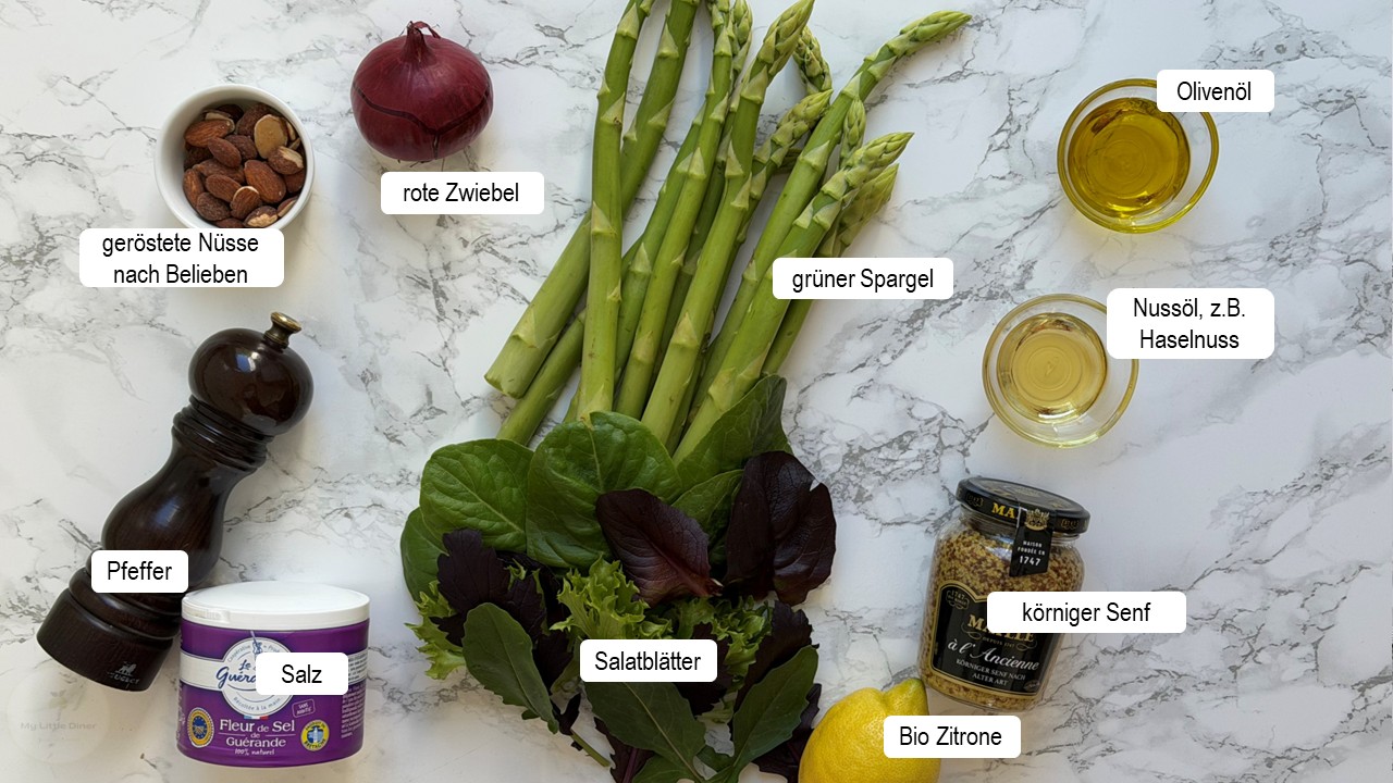 Zutaten für grünen Spargelsalat liegen auf weißem Marmoruntergrund